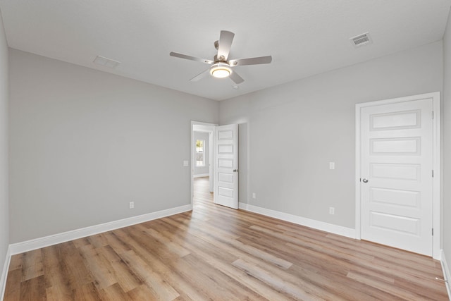 unfurnished room featuring visible vents, ceiling fan, light wood-style flooring, and baseboards