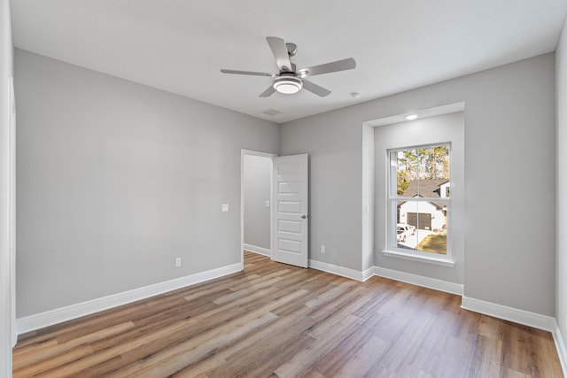 unfurnished bedroom featuring light wood-type flooring, a ceiling fan, and baseboards