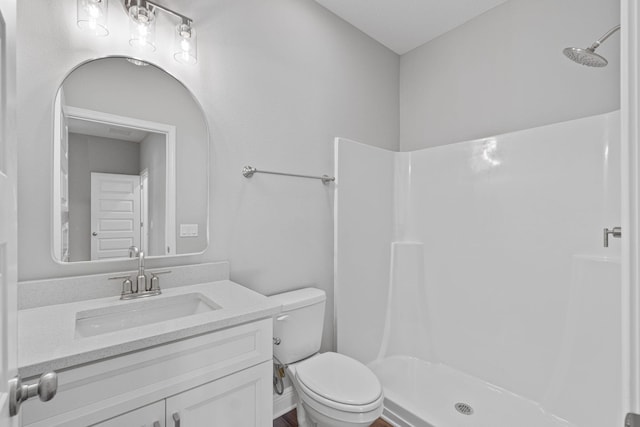 bathroom with a shower, vanity, and toilet