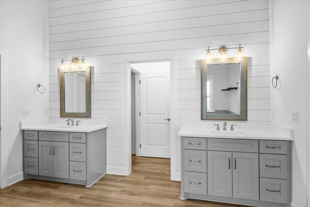 bathroom featuring wood-type flooring, vanity, and wooden walls