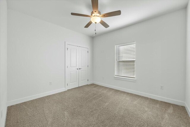 carpeted empty room featuring ceiling fan