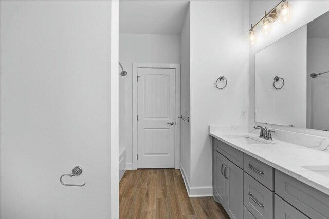 bathroom featuring a tub to relax in, wood-type flooring, and vanity