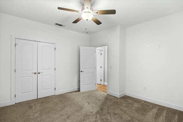 unfurnished bedroom featuring ceiling fan, carpet flooring, and a closet