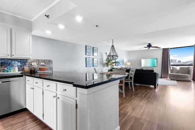 kitchen with white cabinetry, stainless steel dishwasher, backsplash, kitchen peninsula, and hardwood / wood-style floors