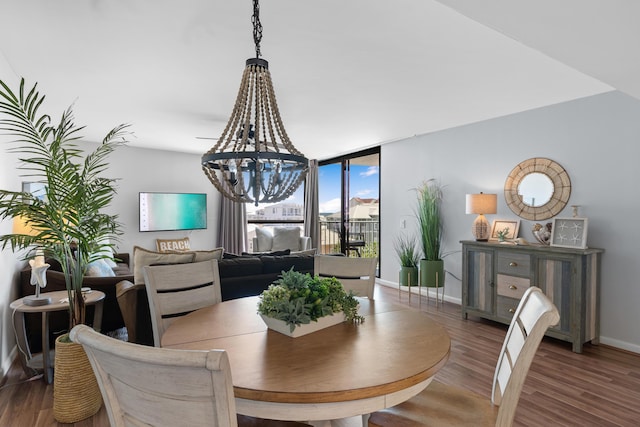 dining space featuring a wall of windows, dark hardwood / wood-style floors, and a notable chandelier