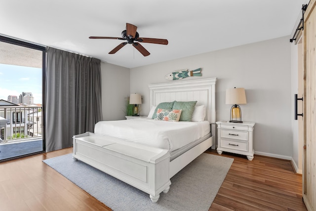 bedroom with multiple windows, a barn door, access to outside, and ceiling fan