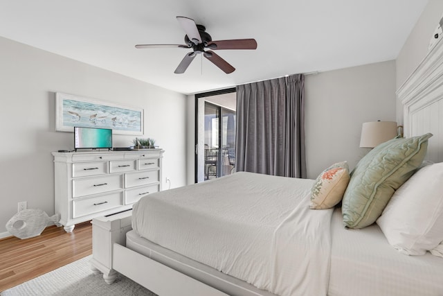 bedroom with ceiling fan, a wall of windows, access to outside, and light hardwood / wood-style flooring