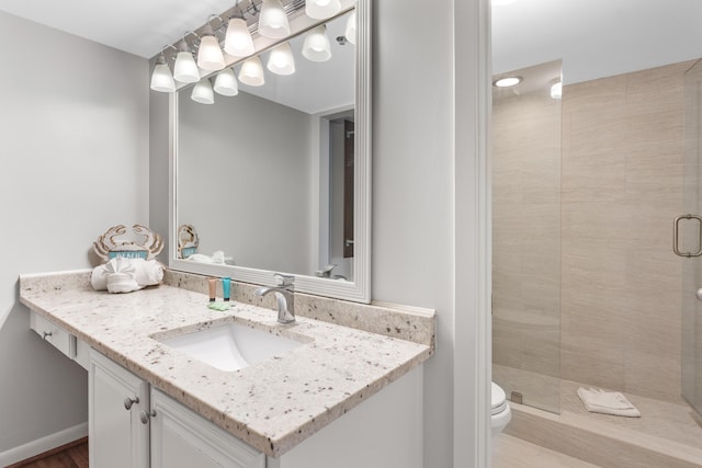 bathroom with vanity, toilet, and a shower with shower door