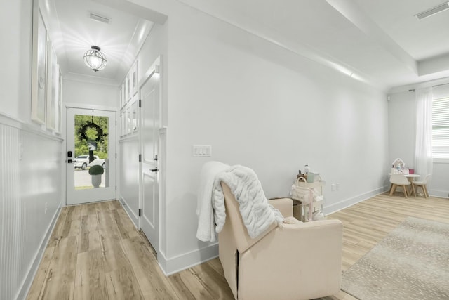 sitting room featuring crown molding and light hardwood / wood-style flooring