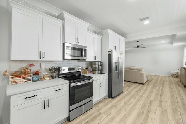 kitchen with white cabinets, appliances with stainless steel finishes, and tasteful backsplash