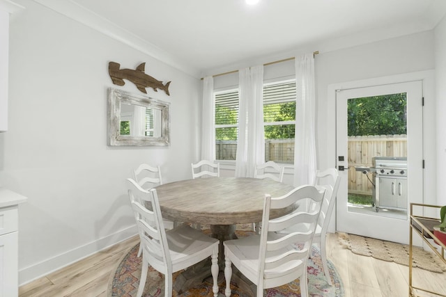 dining room with light hardwood / wood-style floors and ornamental molding