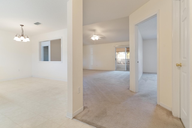 hall with light colored carpet and a notable chandelier