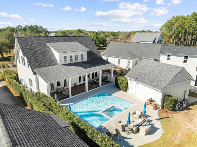 back of house featuring a patio, an in ground hot tub, and outdoor lounge area