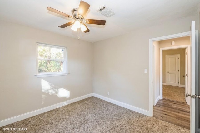 carpeted spare room with ceiling fan