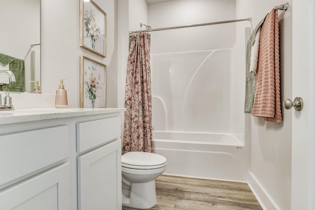 full bathroom featuring hardwood / wood-style flooring, shower / tub combo with curtain, vanity, and toilet