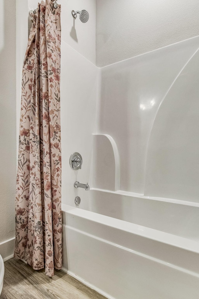 bathroom featuring shower / tub combo and hardwood / wood-style flooring