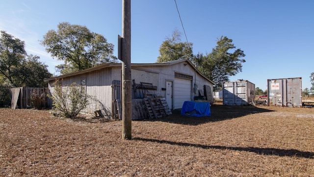 view of property exterior with a garage and an outdoor structure