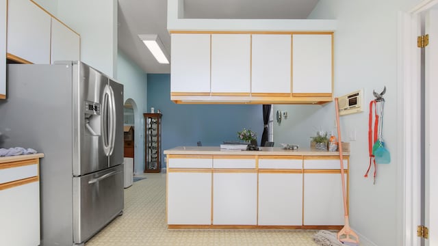 kitchen featuring white cabinetry and stainless steel fridge