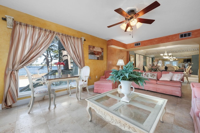 living room with a water view and ceiling fan with notable chandelier