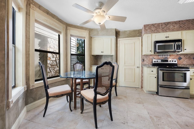 kitchen featuring stainless steel range with electric stovetop, ceiling fan, and light stone counters