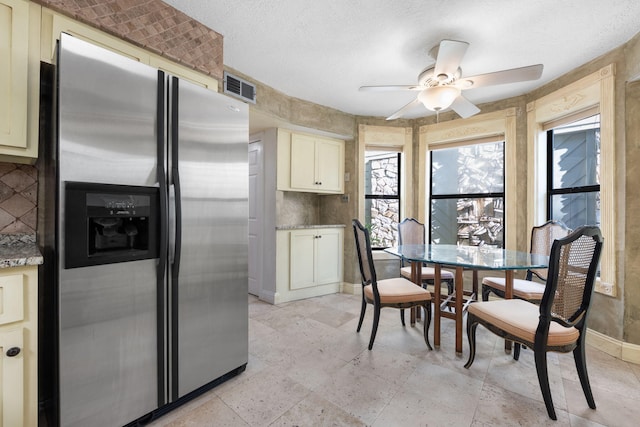 kitchen with cream cabinetry, ceiling fan, and stainless steel fridge with ice dispenser