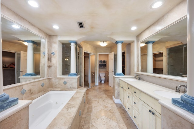 bathroom with vanity, a relaxing tiled tub, toilet, and decorative columns