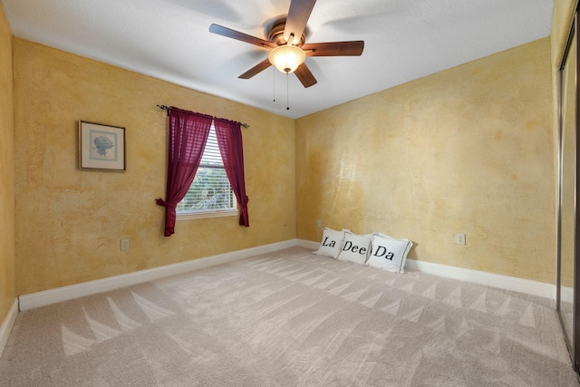 carpeted empty room featuring ceiling fan