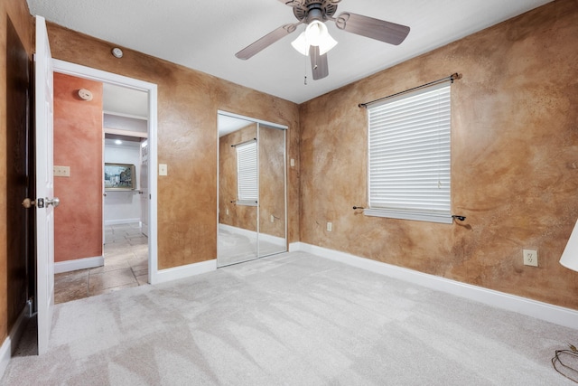 unfurnished bedroom with ceiling fan, light carpet, and a closet