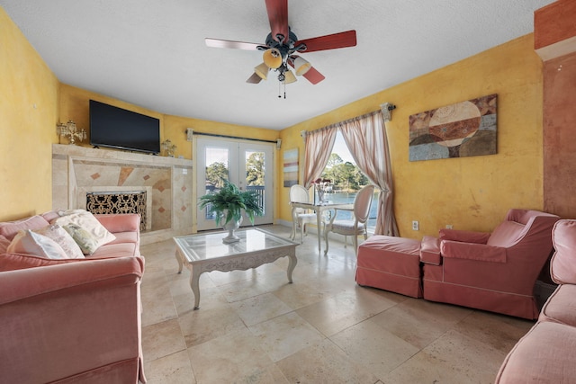 living room with french doors, a textured ceiling, and ceiling fan