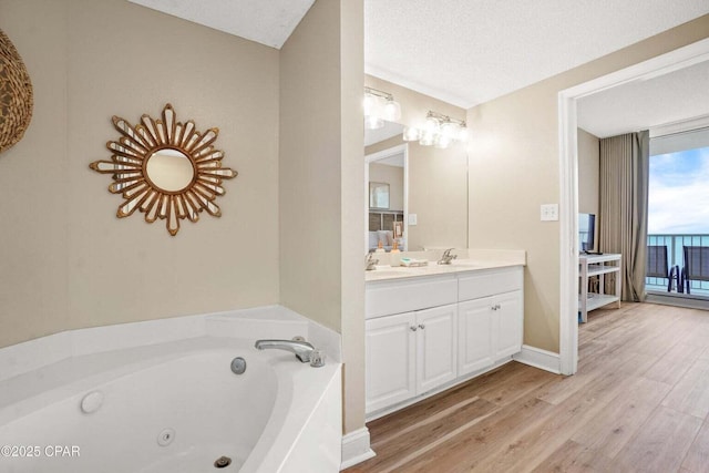 bathroom with vanity, a bath, a textured ceiling, and wood-type flooring