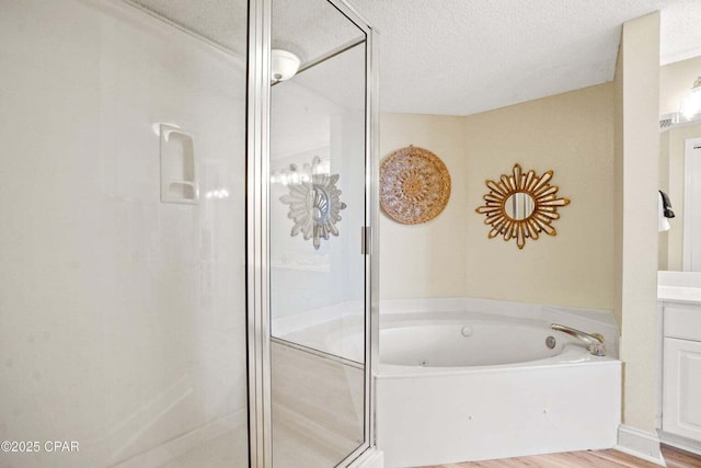 bathroom with vanity, hardwood / wood-style floors, a textured ceiling, and separate shower and tub