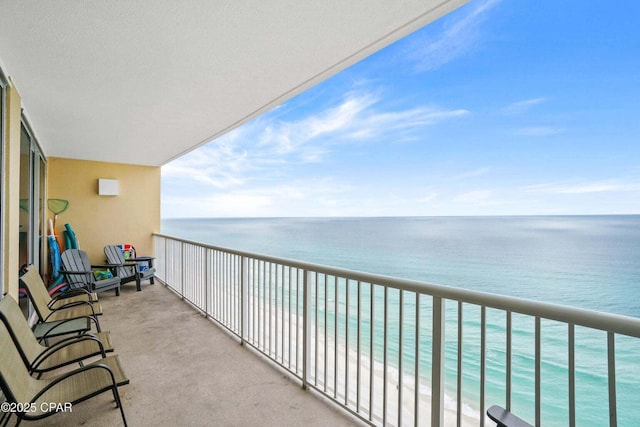 balcony featuring a view of the beach and a water view