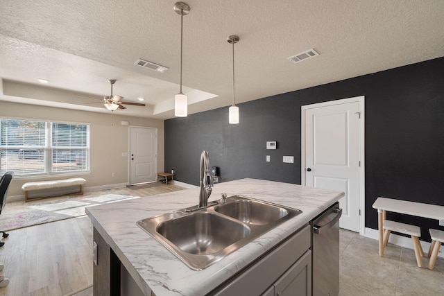 kitchen with ceiling fan, sink, pendant lighting, a center island with sink, and dishwasher