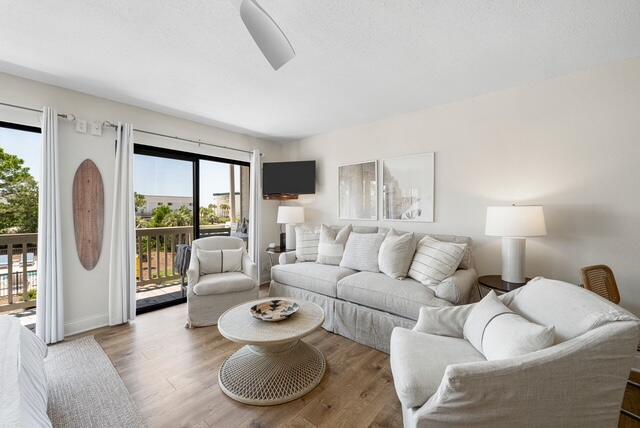 living room featuring hardwood / wood-style flooring, a wealth of natural light, and ceiling fan