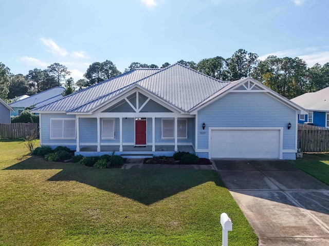 view of front of home featuring a front yard, a garage, and covered porch