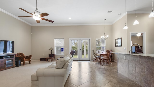 living room with ceiling fan with notable chandelier, sink, crown molding, and french doors