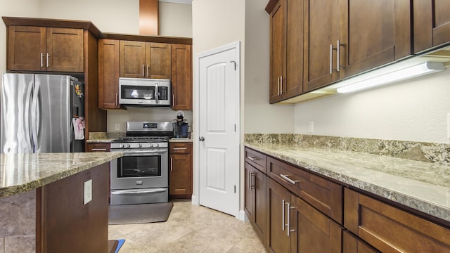 kitchen with light stone counters and appliances with stainless steel finishes