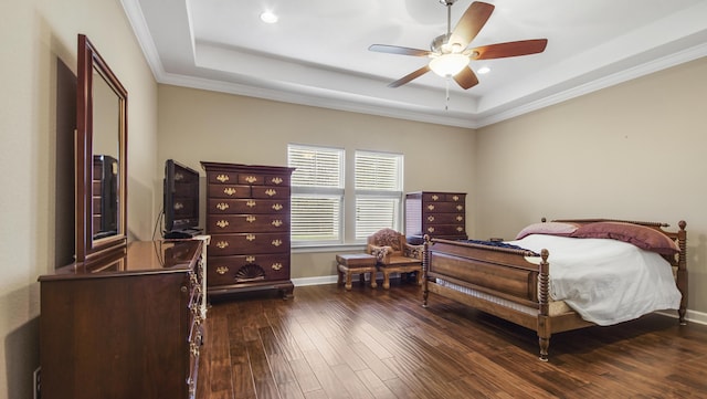 bedroom with a tray ceiling, ceiling fan, ornamental molding, and dark hardwood / wood-style floors