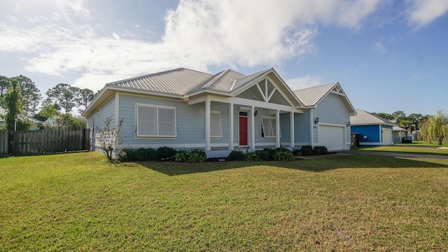 view of front of house with a garage, covered porch, and a front lawn