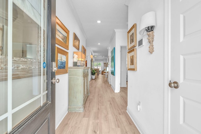 corridor featuring crown molding and light hardwood / wood-style flooring