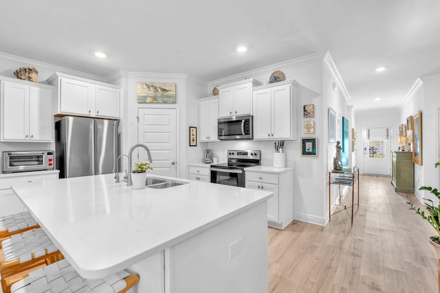 kitchen with a breakfast bar, stainless steel appliances, a center island with sink, and sink