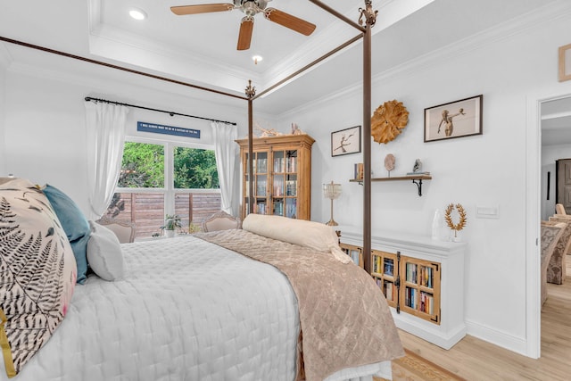 bedroom with a raised ceiling, ceiling fan, light hardwood / wood-style floors, and ornamental molding