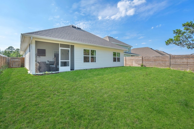 rear view of property with a sunroom and a yard