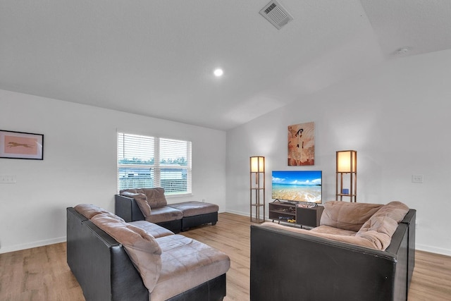 living room with light hardwood / wood-style floors and vaulted ceiling