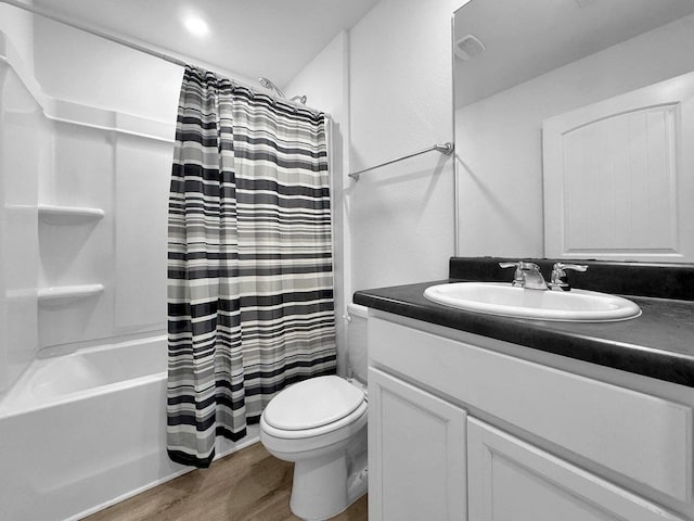 full bathroom with toilet, hardwood / wood-style floors, vanity, and shower / tub combo with curtain