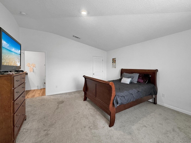 carpeted bedroom with a textured ceiling and lofted ceiling