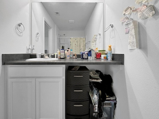 bathroom featuring curtained shower and vanity