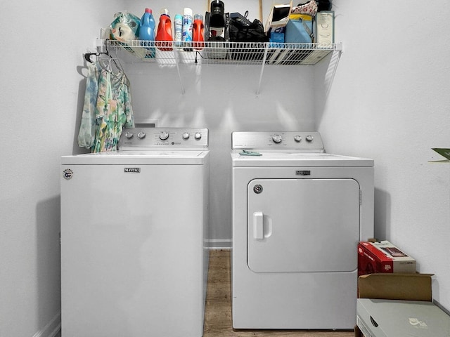 laundry room with hardwood / wood-style flooring and washing machine and dryer