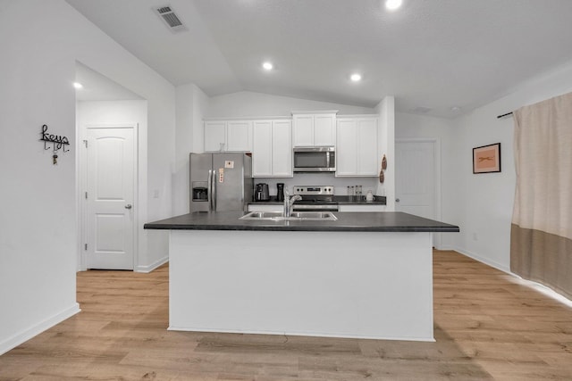 kitchen featuring white cabinets, stainless steel appliances, and a center island with sink