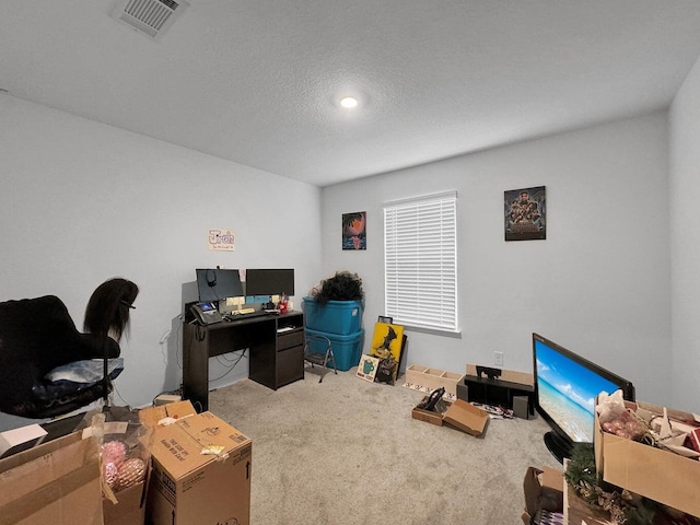 carpeted home office featuring a textured ceiling